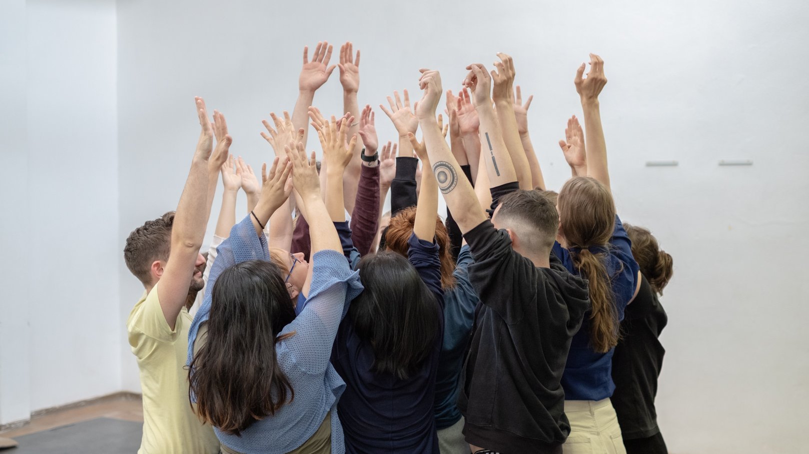Gruppe Menschen stehen zusammen mit den Armen in die Luft 