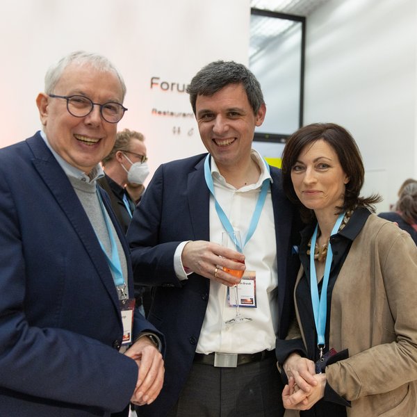 Eindrücke der Auftaktveranstaltung: Zwei Männer und eine Frau stehen lächelnd vor der Kamera..