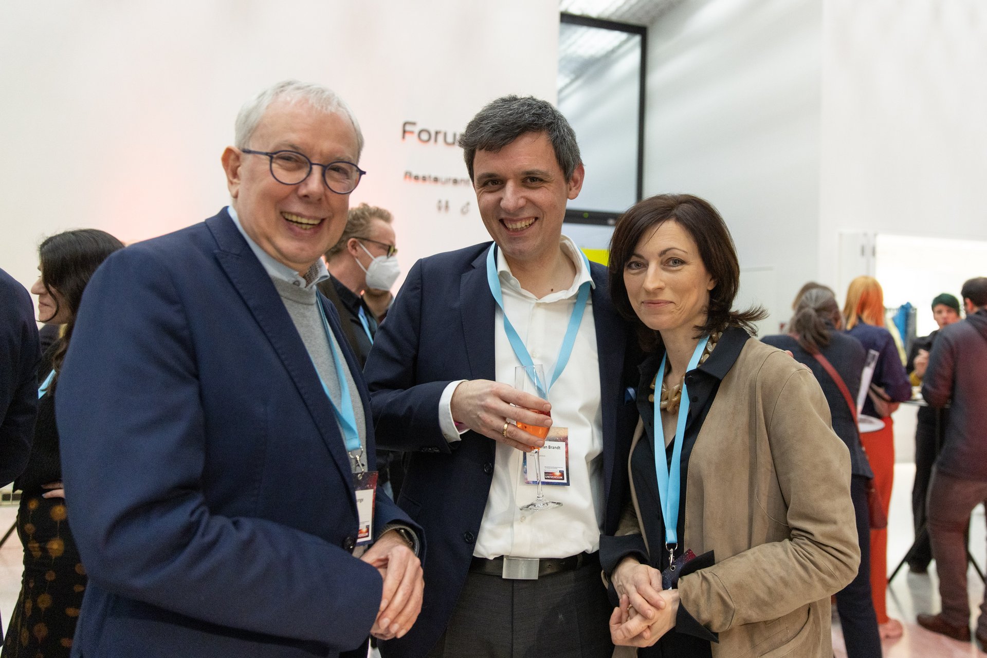 Eindrücke der Auftaktveranstaltung: Zwei Männer und eine Frau stehen lächelnd vor der Kamera..