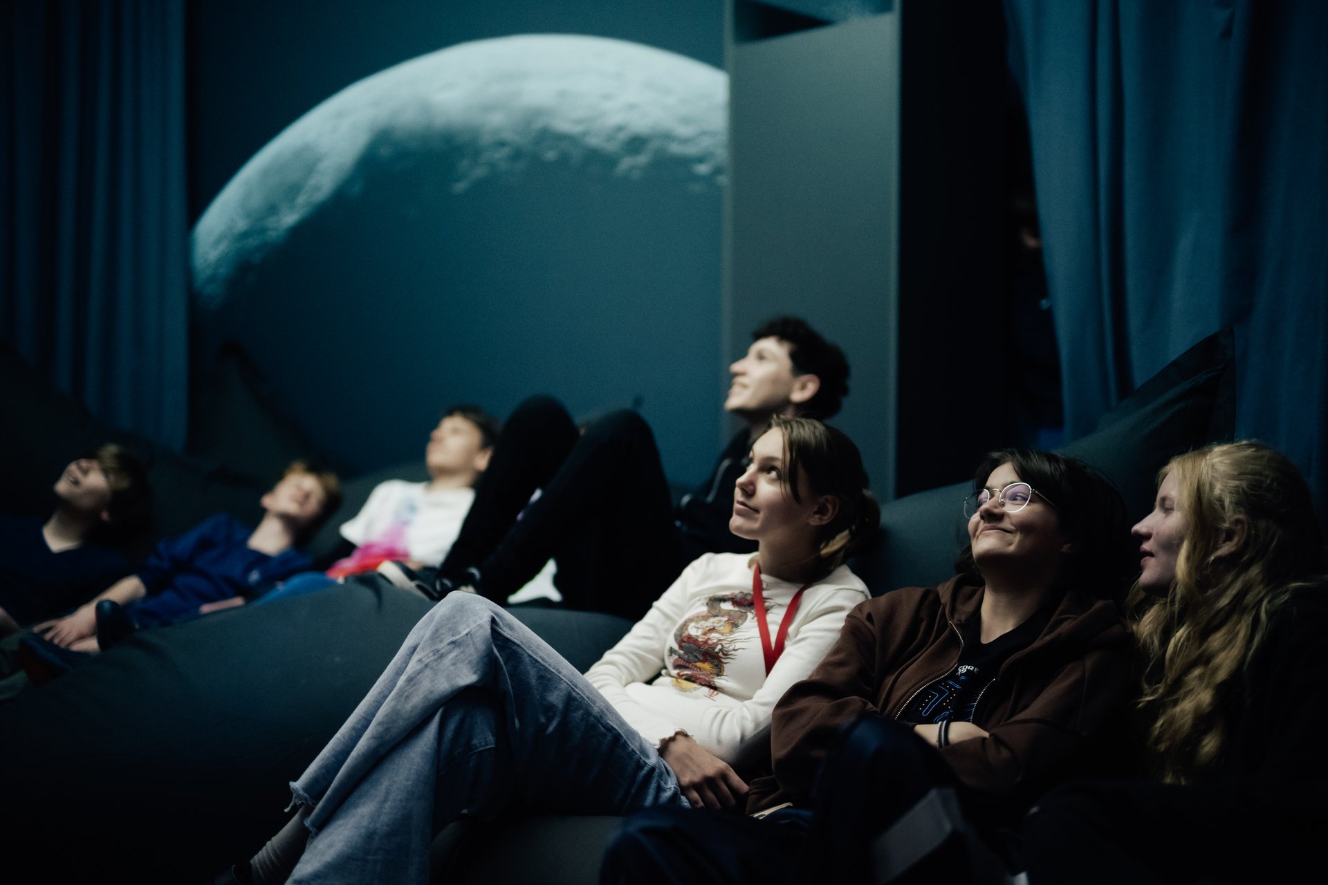 Personengruppe auf einem Sofa, die sich ein Ausstellungsexponat ansehen