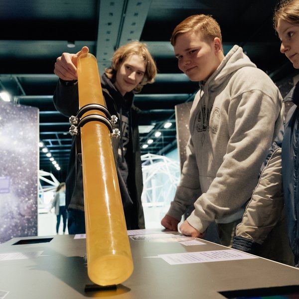 Drei Personen begutachten ein Ausstellungsstück.