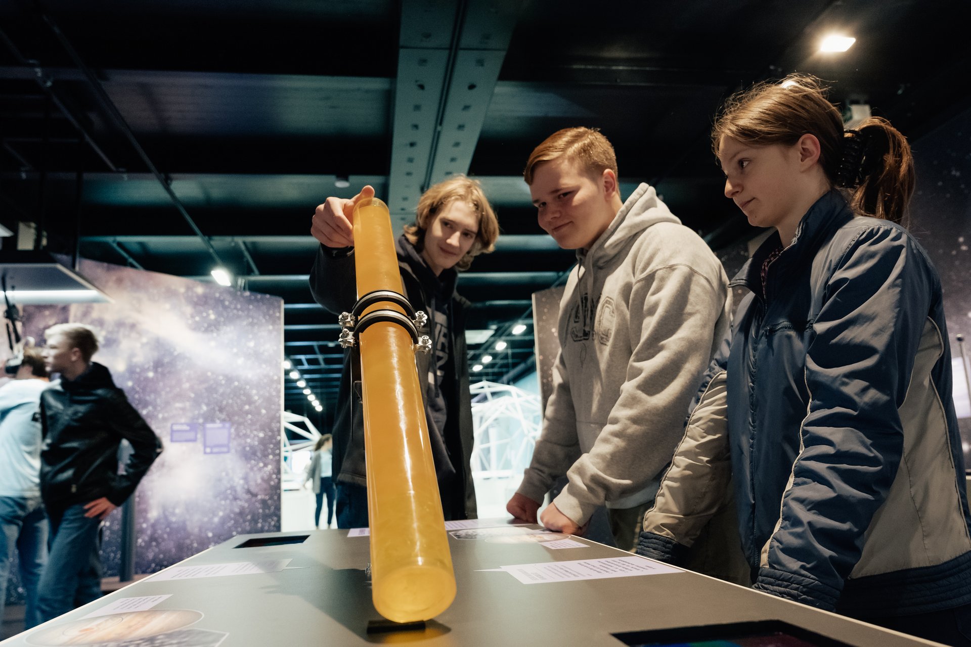 Drei Personen begutachten ein Ausstellungsstück.
