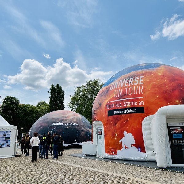 Foto des Planetariumszelts und des Begleitzelts unter blauem Himmel