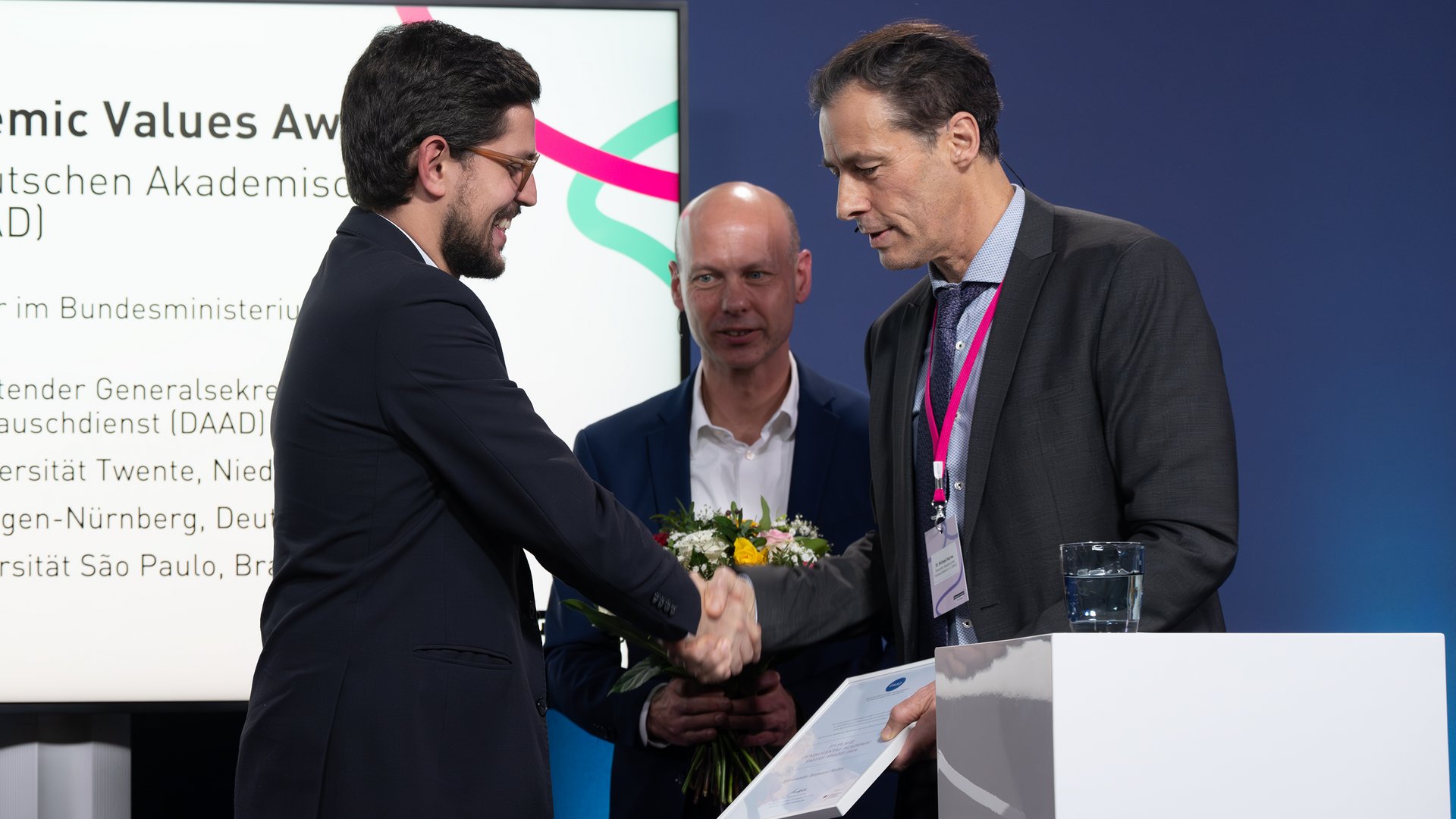 Dr. Michael Harms gratuliert Fundamental Academic Values Award-Drittplatziertem Fernando Romani Sales.