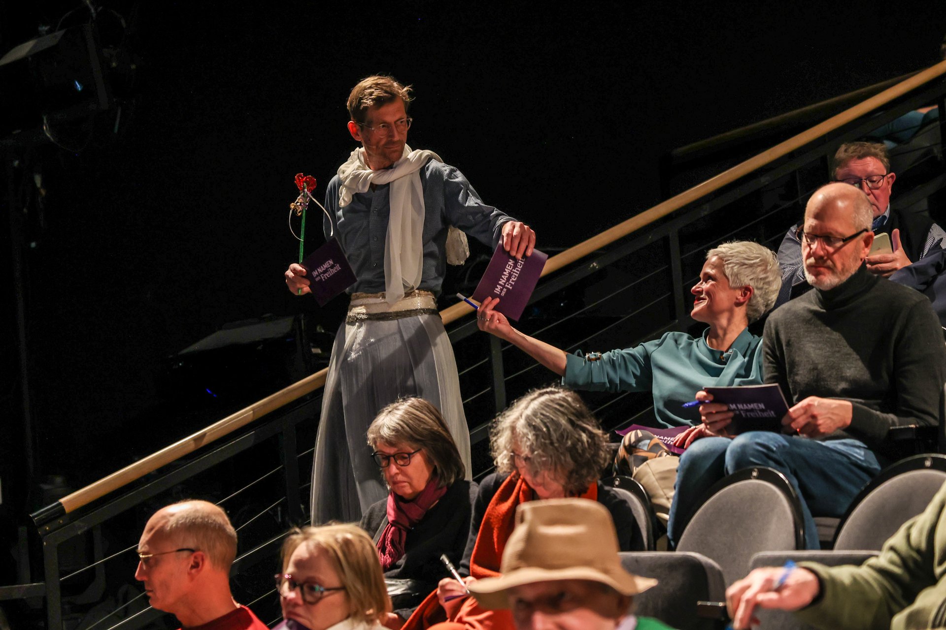 Uwe Gössel als Fee verkleidet verteilt Karten im Publikum.