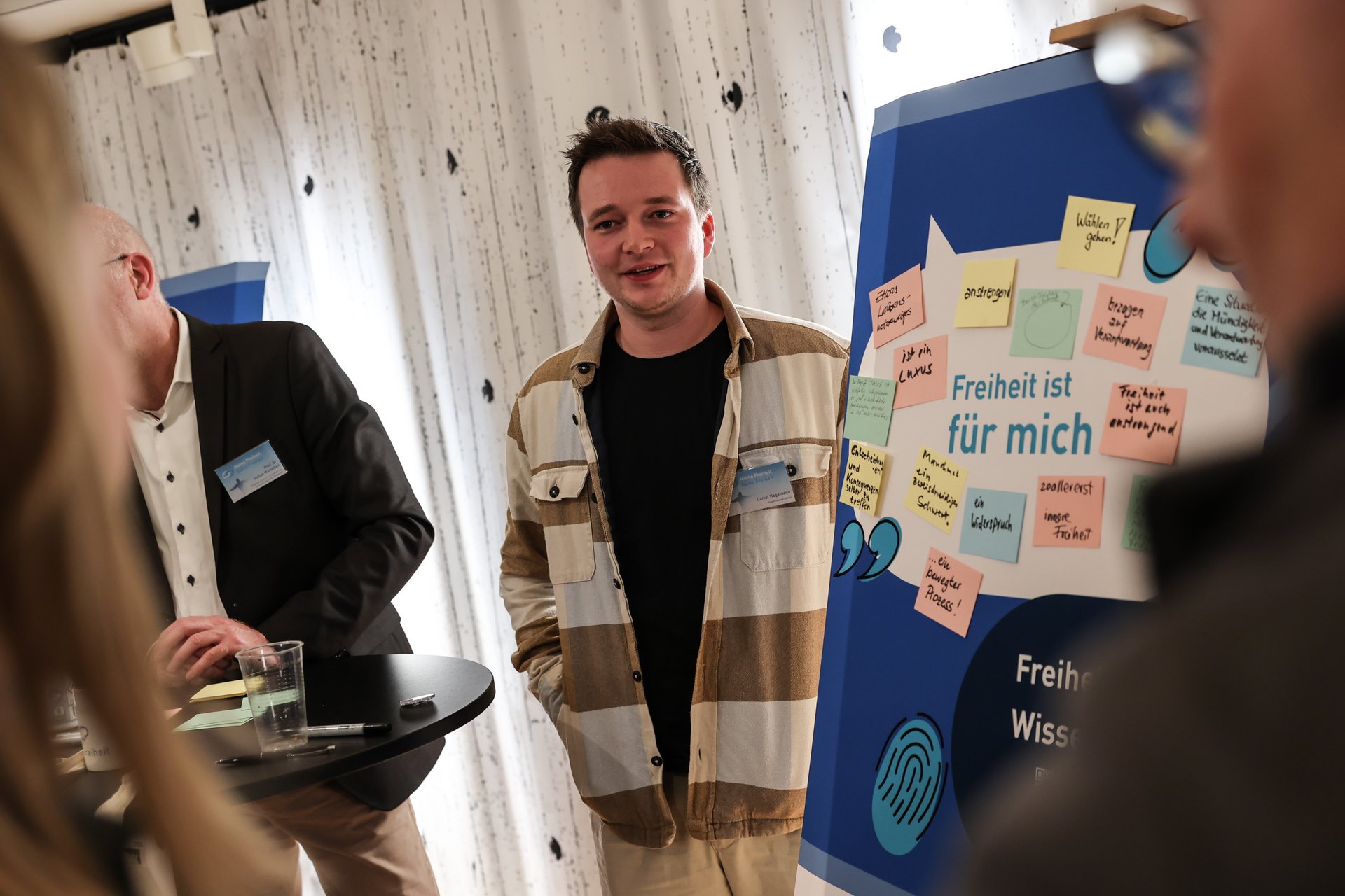Ein Student der Bürger-Uni Düsseldorf steht neben einer Tafel mit Notizen zu Freiheit.
