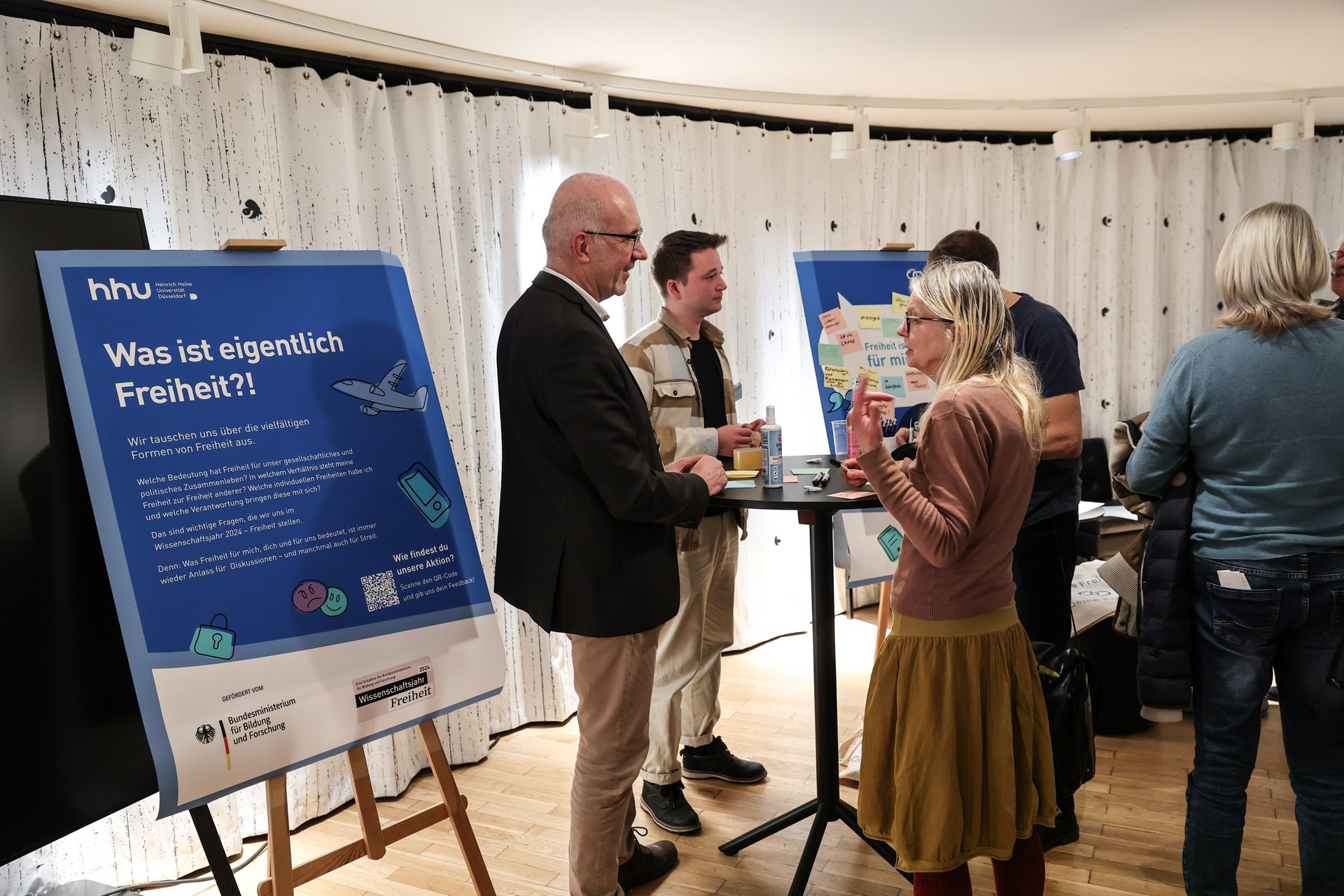 Studierende der Bürger-Uni Düsseldorf stellen im Foyer ihre Ergebnisse vor.