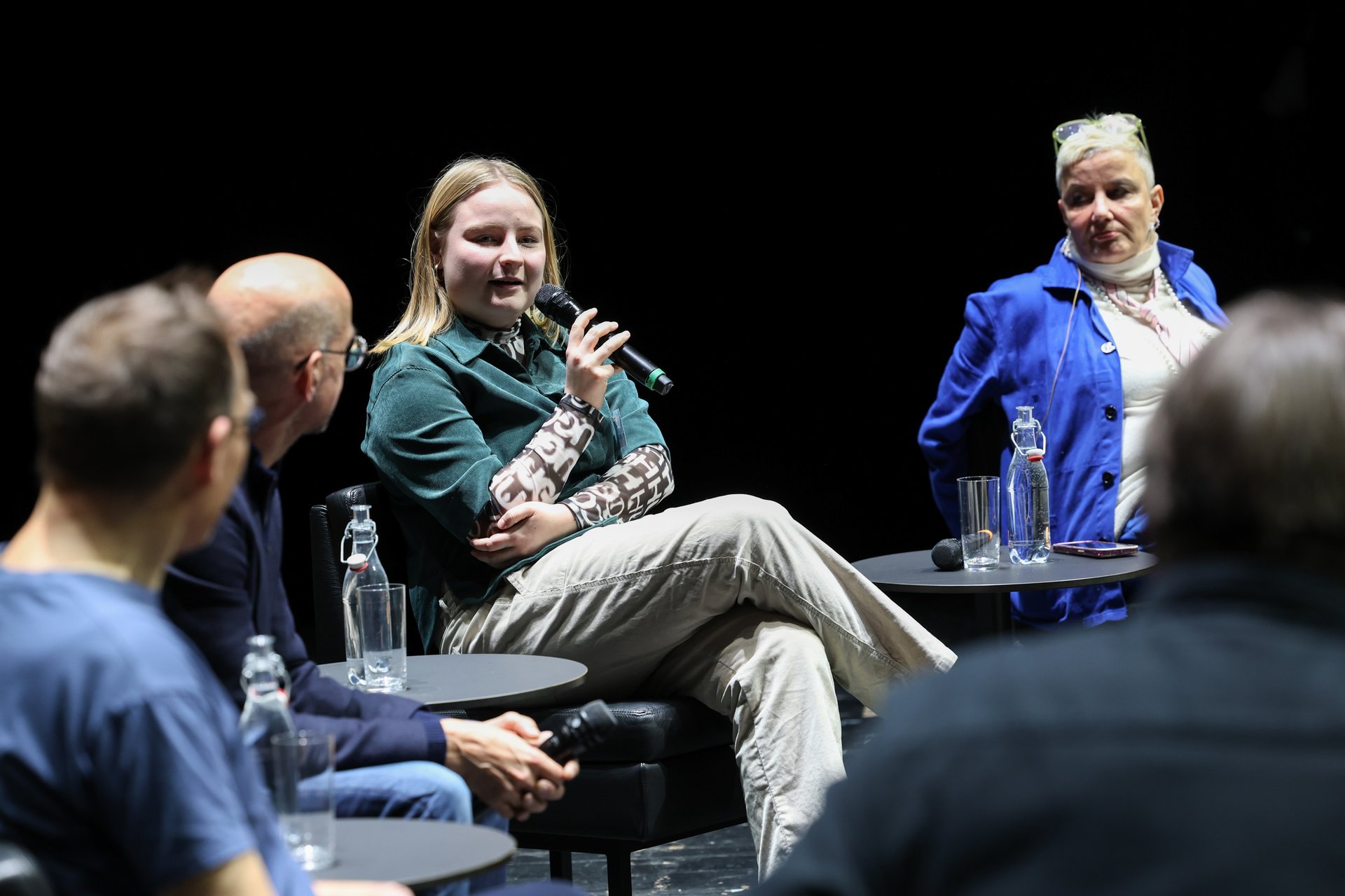 Eine Frau spricht bei der Podiumsdiskussion ins Mikrofon.