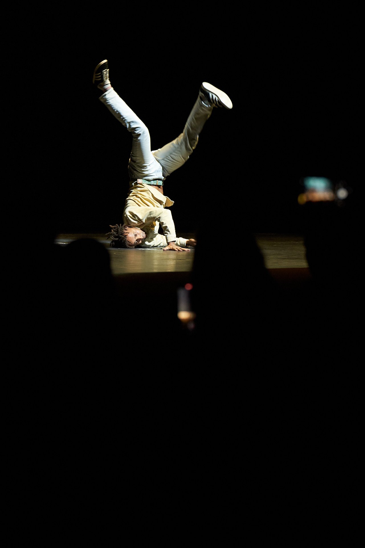 Raphael Moussa Hillebrand tanzt kopfüber auf der Bühne.