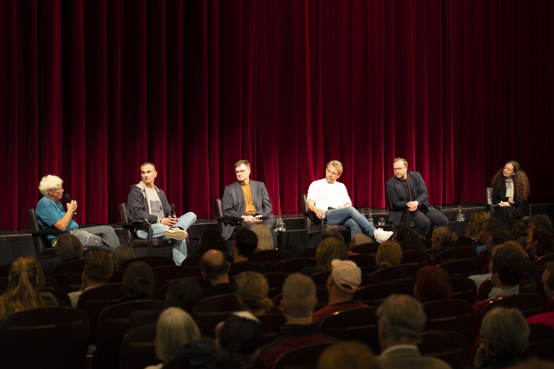 Das Panel der Theaterversammlung sitzen auf der Bühne. Neben Moderatorin Shelly Kupferberg sind unter anderem Thorleifur Örn Arnarsson und Thorsten Logge zu sehen. 
