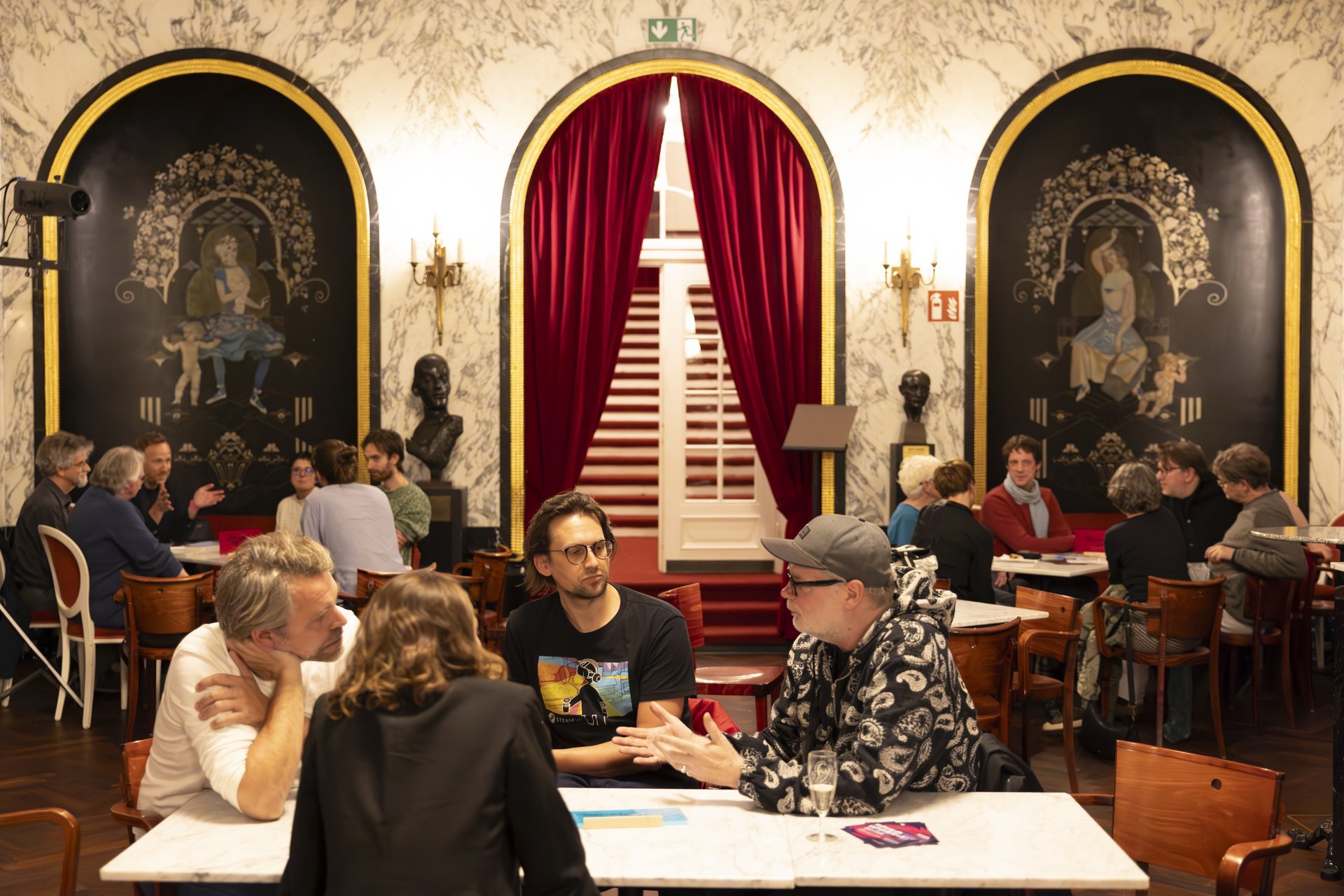 Besuchende der Veranstaltung diskutieren in Gesprächsrunden. 