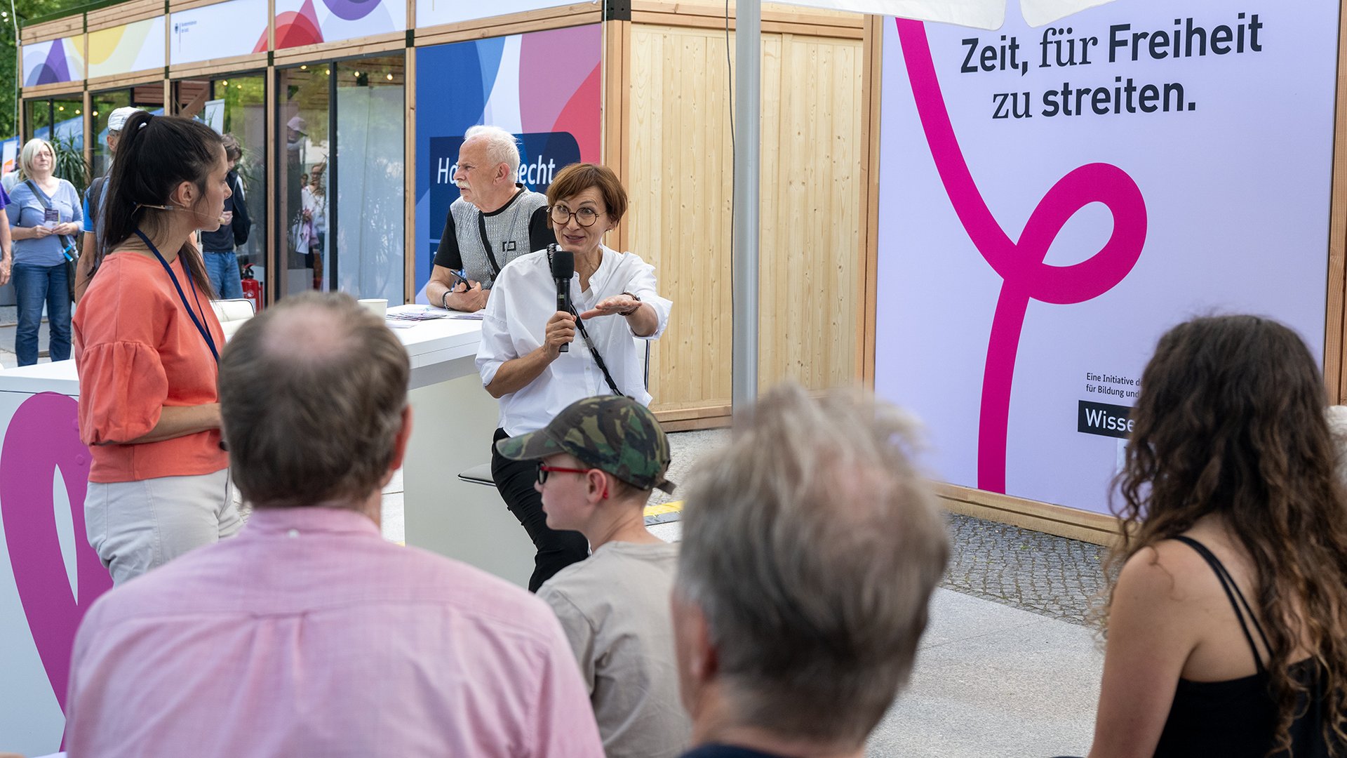 Bundesforschungsministerin Stark-Watzinger spricht vor jungen und alten Menschen auf dem Demokratiefest.