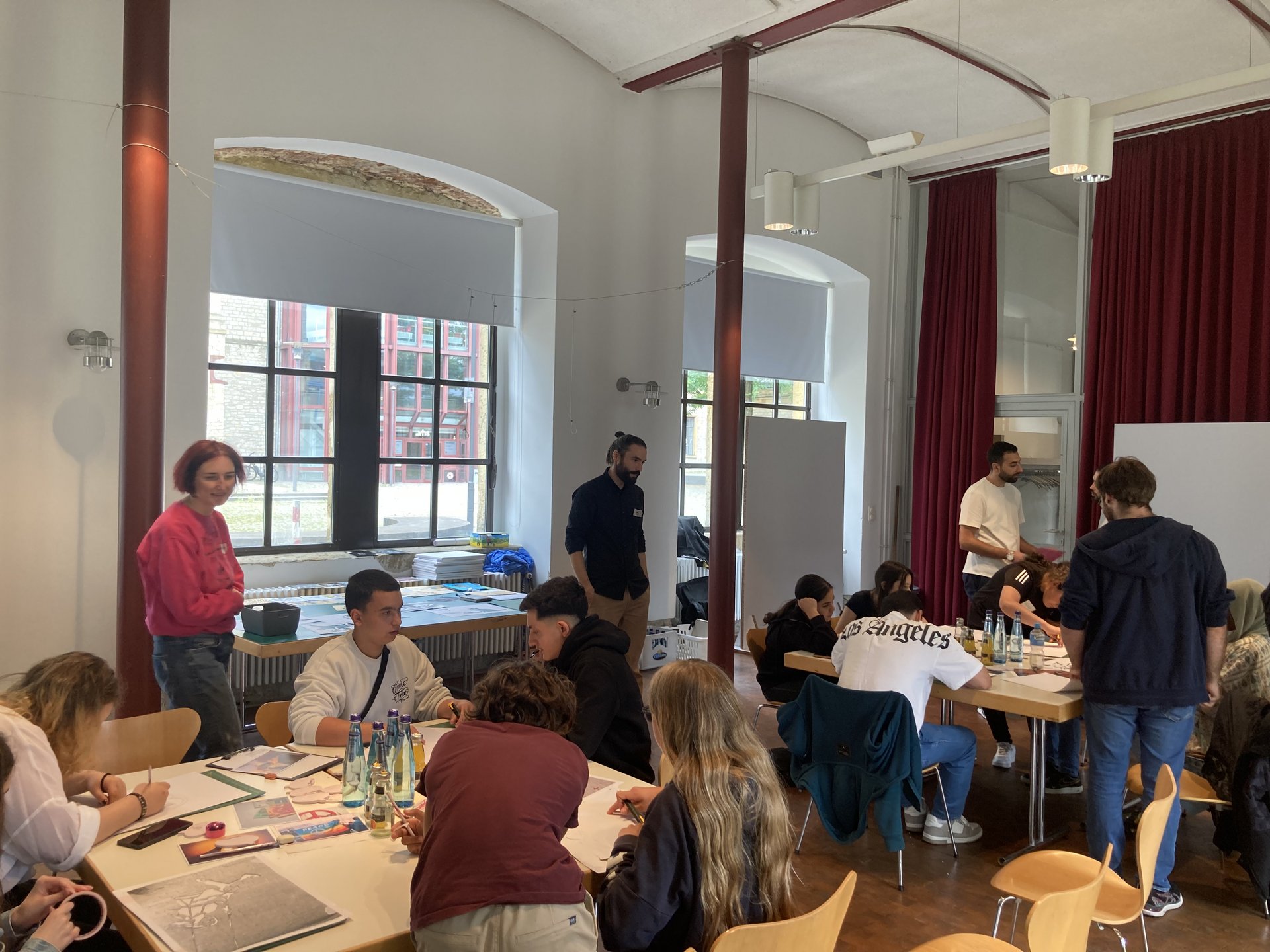 Die Teilnehmenden des Workshops erarbeiten an Gruppentischen verschiedene Designs.