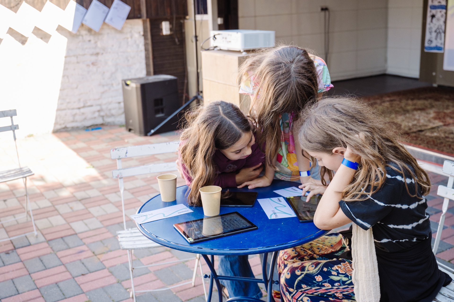 Drei Schülerinnen arbeiten an einem Tablet.
