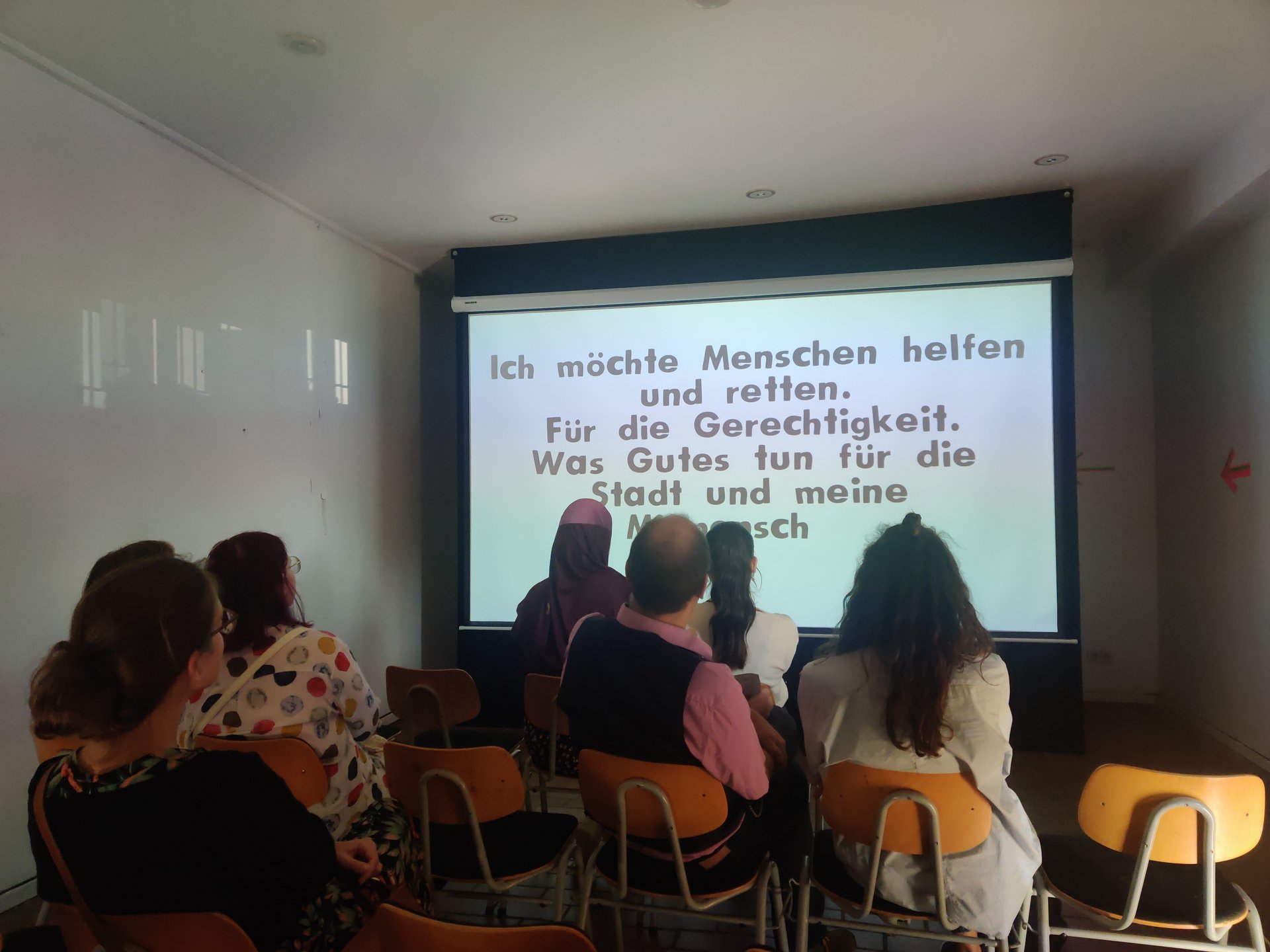 Schülerinnen und Schüler schauen einen Animationsfilm in einem kleinen Kino.