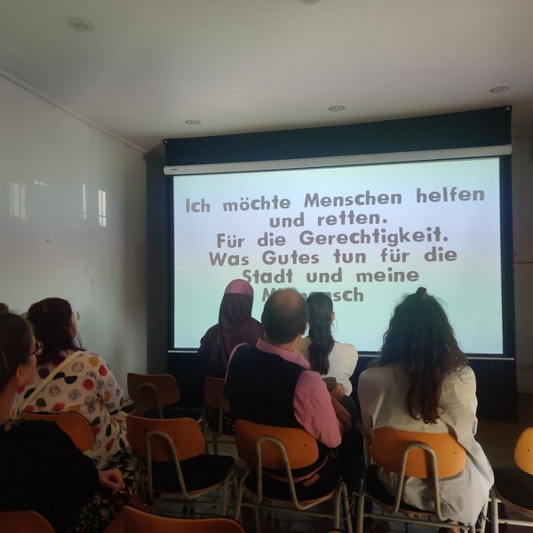 Schülerinnen und Schüler schauen einen Animationsfilm in einem kleinen Kino.