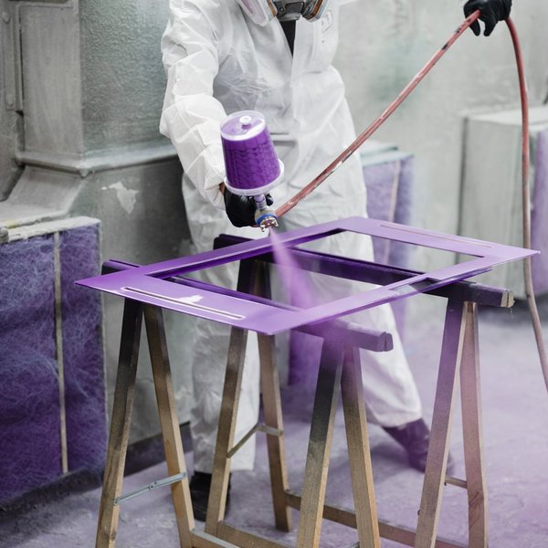 Eine Person sprüht lila Farbe auf die Bauelemente der Erzählbox.