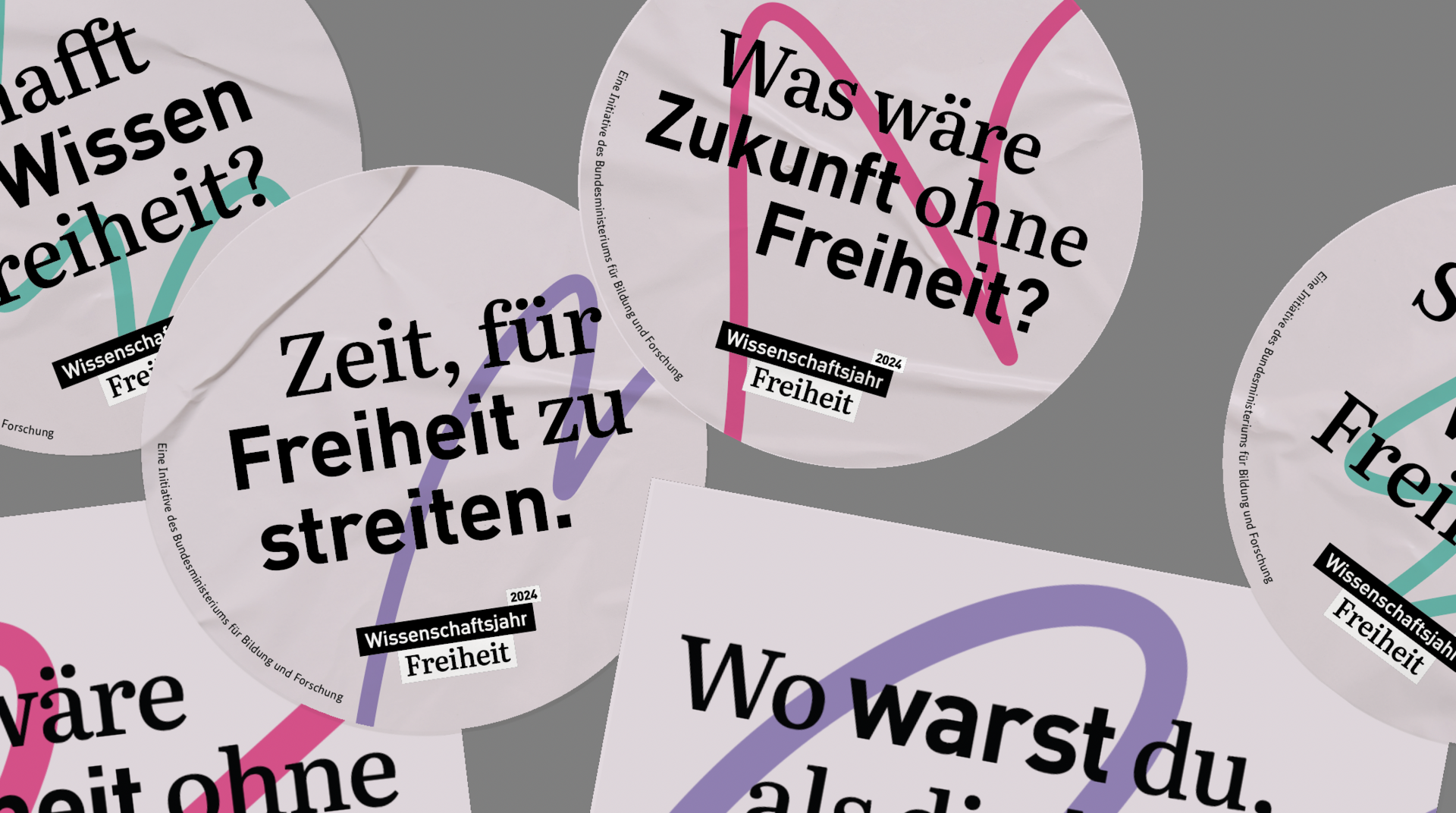 Sticker und eine Postkarte zum Wissenschaftsjahr 2024. Darauf steht zum Beispiel "Zeit, für Freiheit zu streiten" oder "Was wäre Zukunft ohne Freiheit?".