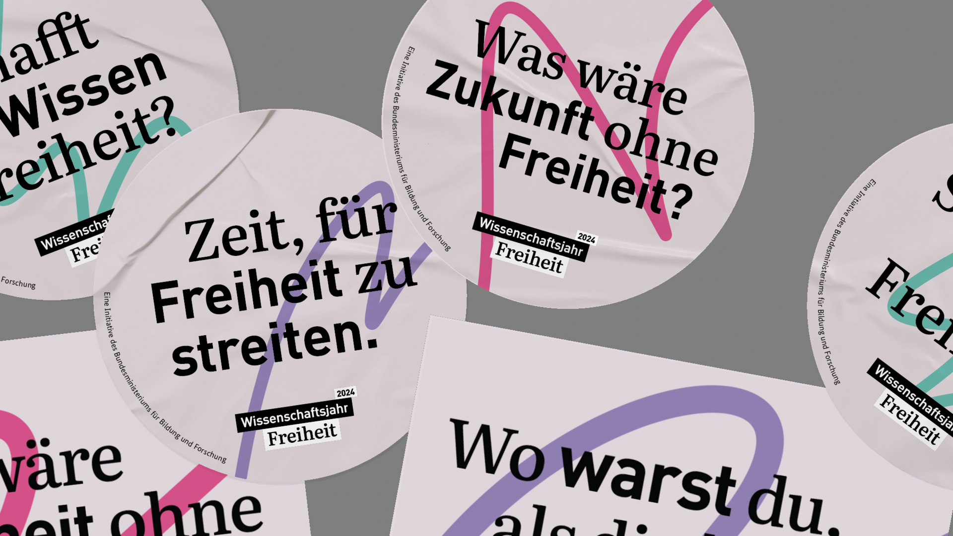 Sticker und eine Postkarte zum Wissenschaftsjahr 2024. Darauf steht zum Beispiel "Zeit, für Freiheit zu streiten" oder "Was wäre Zukunft ohne Freiheit?".