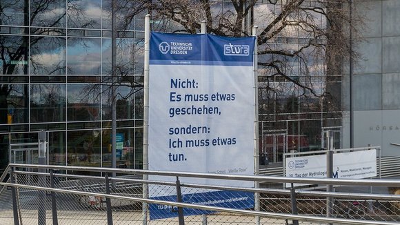 Banner vor der TU Dresden mit der Aufschrift "Nicht: Es muss etwas geschehen, sondern: Ich muss etwas tun".
