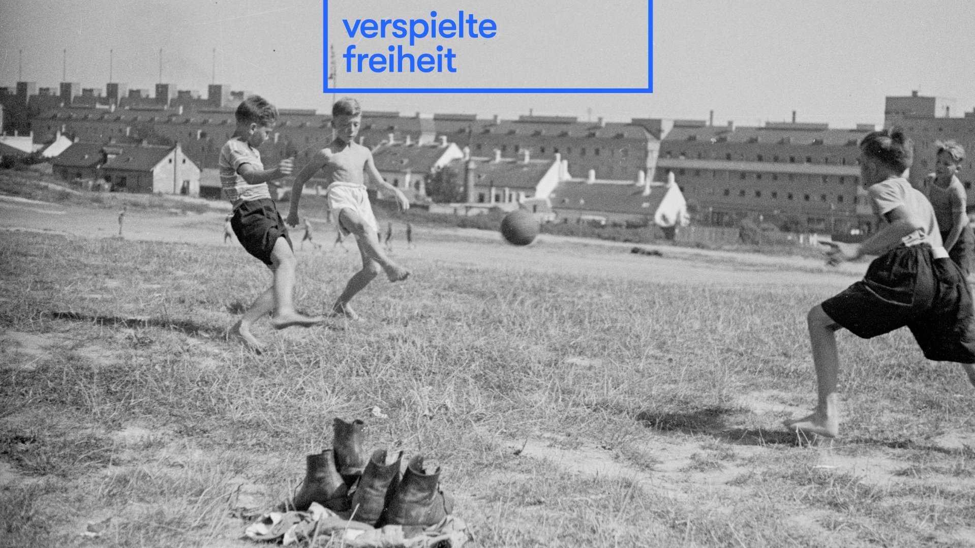 Schwarz-weiß Fotografie von Jungen, die Fußball spielen.