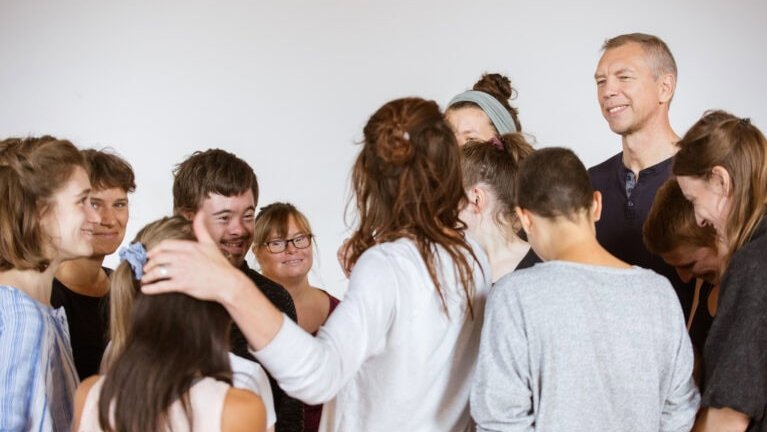 Eine Gruppe von Menschen steht im Kreis zusammen.