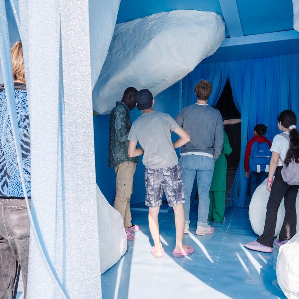 Mehrere Besuchende stehen am Eingang einer Kunstinstallation.