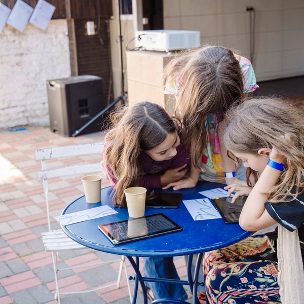 Drei Schülerinnen arbeiten an einem Tablet.