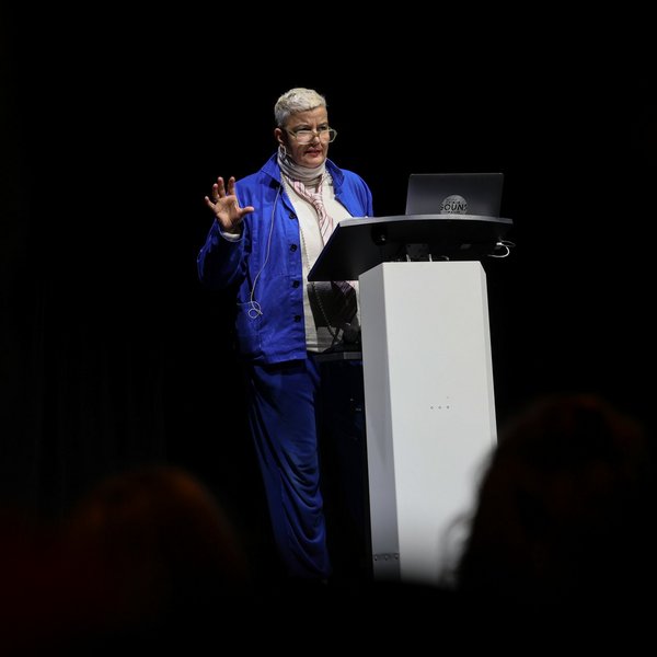 Sibylle Peters spricht auf der Bühne hinter einem Podium.