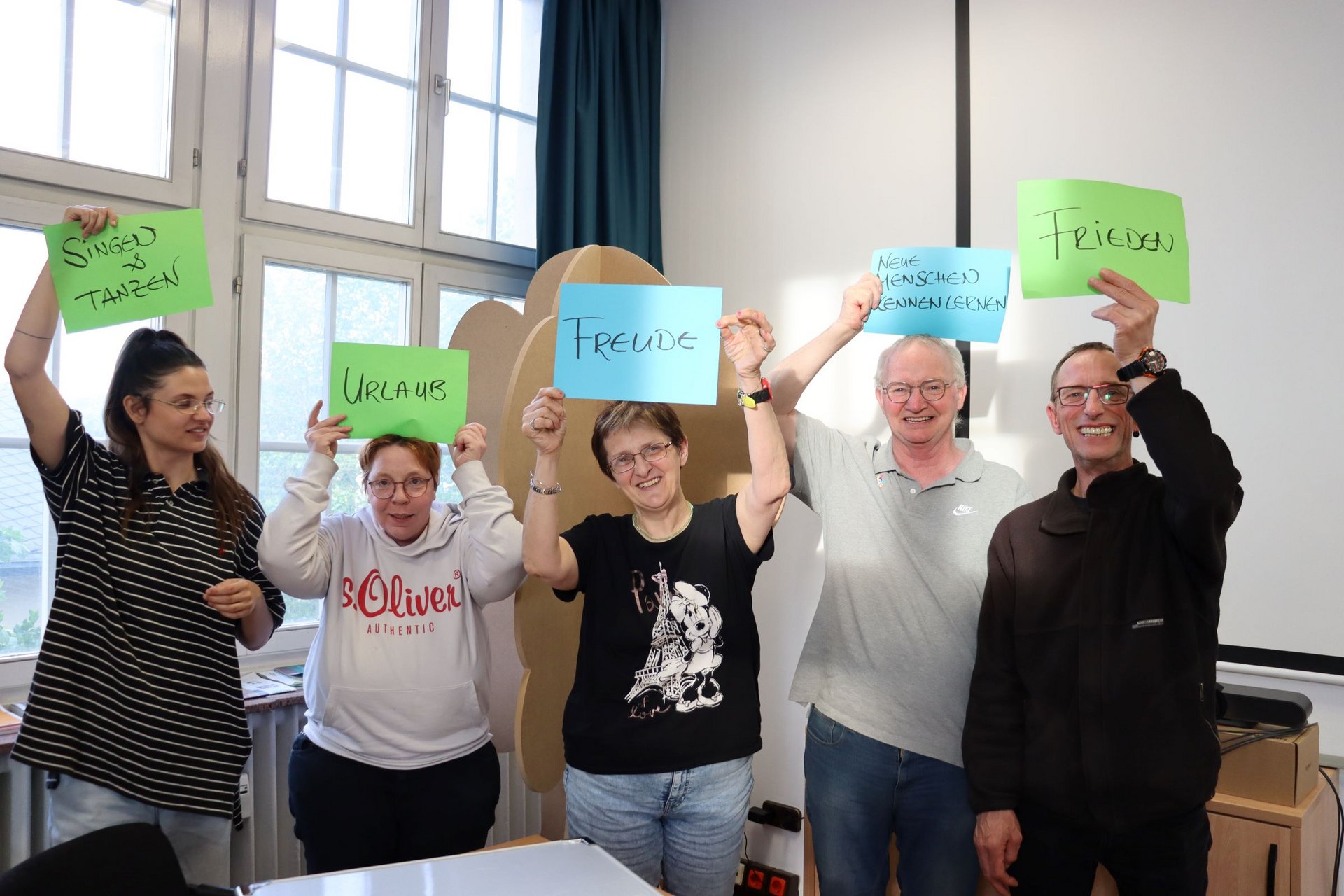 Foto einer Lebenshilfe-Gruppe, sie halten Schilder mit Ideen zu Freiheit hoch.