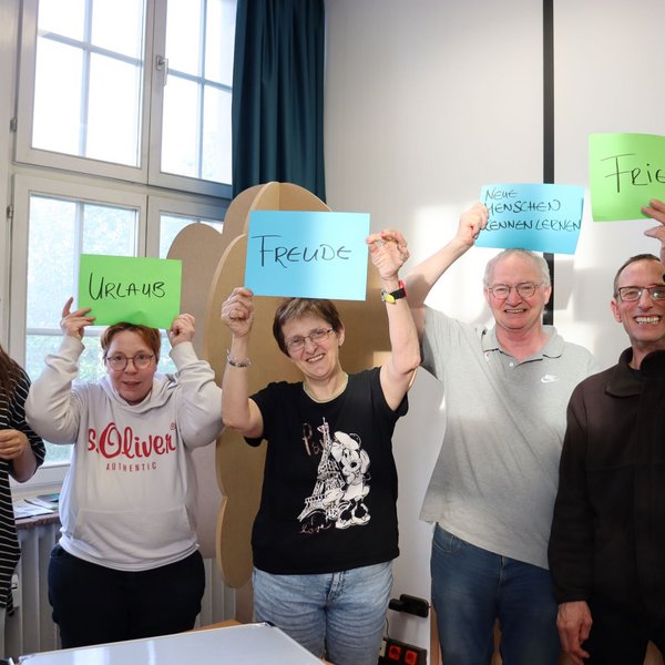 Foto einer Lebenshilfe-Gruppe, sie halten Schilder mit Ideen zu Freiheit hoch.