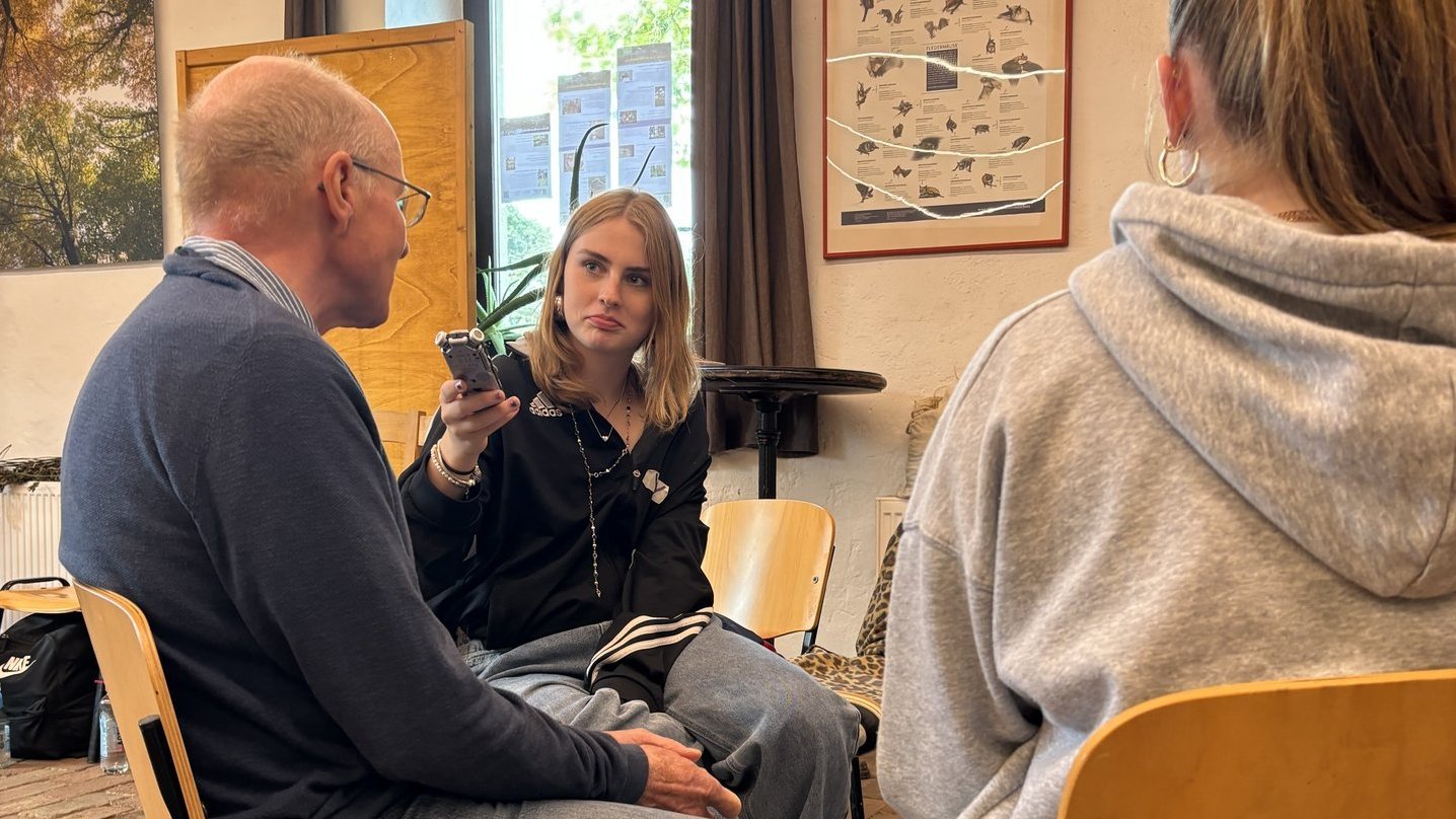 Eine Schülerin interviewt einen Rentner.