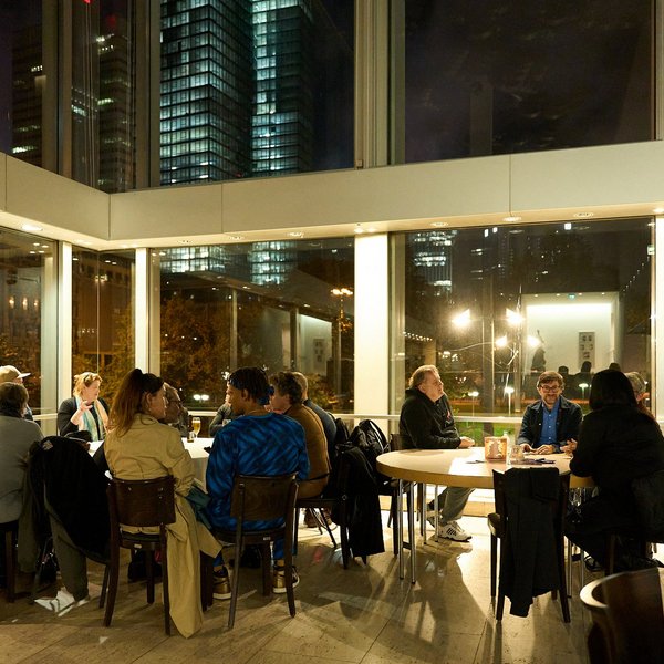 Die Expertinnen und Experten sitzen mit Besuchenden bei Tischgesprächen zusammen.