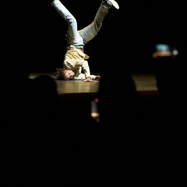 Raphael Moussa Hillebrand tanzt kopfüber auf der Bühne.