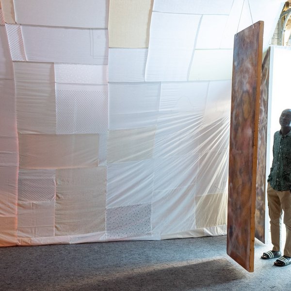 Ein Mann betritt einen Raum mit gespannten Tüchern.