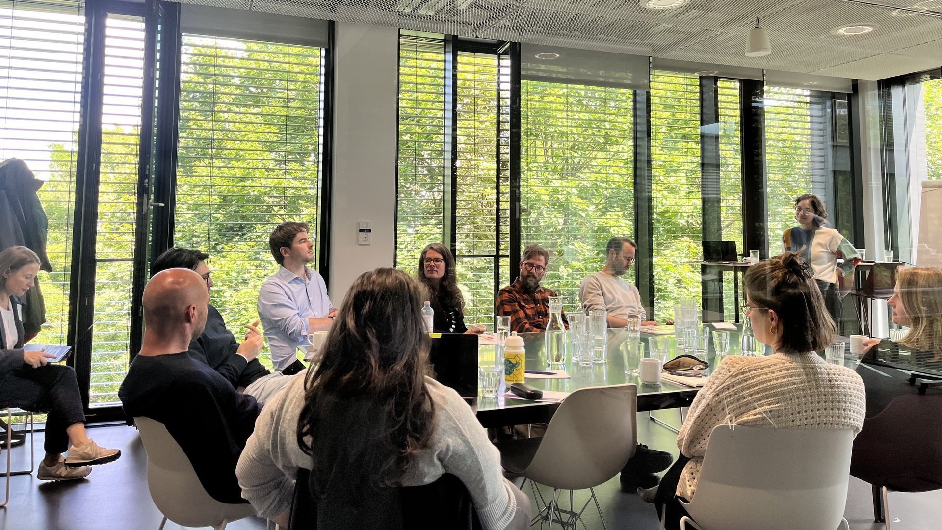 Eine Gruppe Menschen sitzt um einen Konferenztisch.