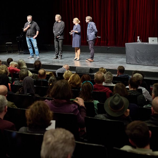 Die Verantwortlichen für die Theaterversammlung in Rostock mit Cordula Kleidt auf der Bühne vor Publikum.