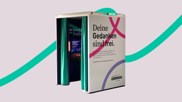 Foto von der Erzählbox vor der grünen Linie. Auf der Seite steht "Deine Gedanken sind frei".