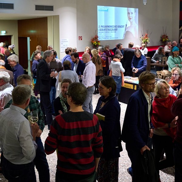 Gäste unterhalten sich im Foyer des Volkstheaters Rostock.