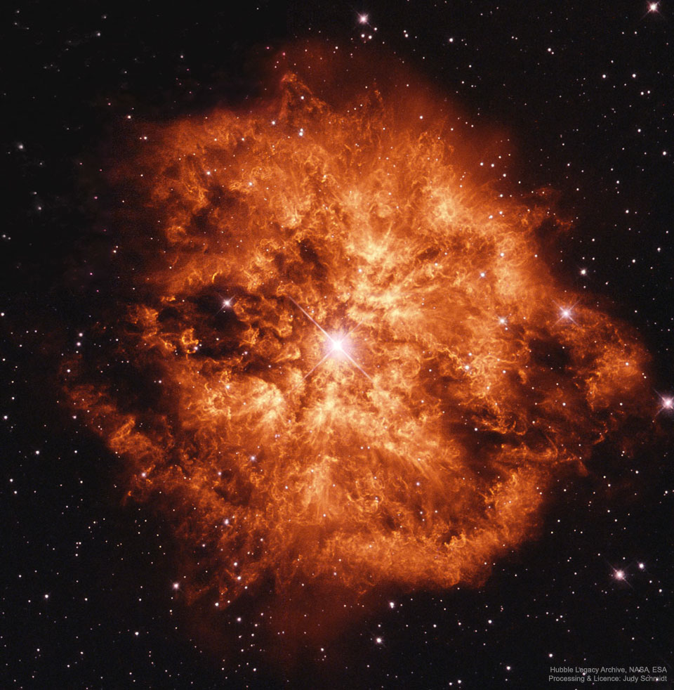 Ein heller Stern inmitten einer orangefarbenen Wolke vor einem dunklen Sternenhimmel