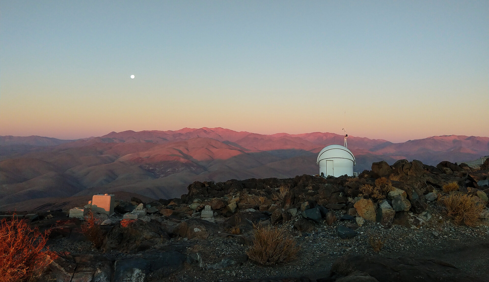 Das Testbed Telescope 2 der ESA am La-Silla-Observatorium der ESO in Chile blickt bei Sonnenuntergang auf die Atacama-Wüste. Links im Bild ist der Mondaufgang zu sehen.