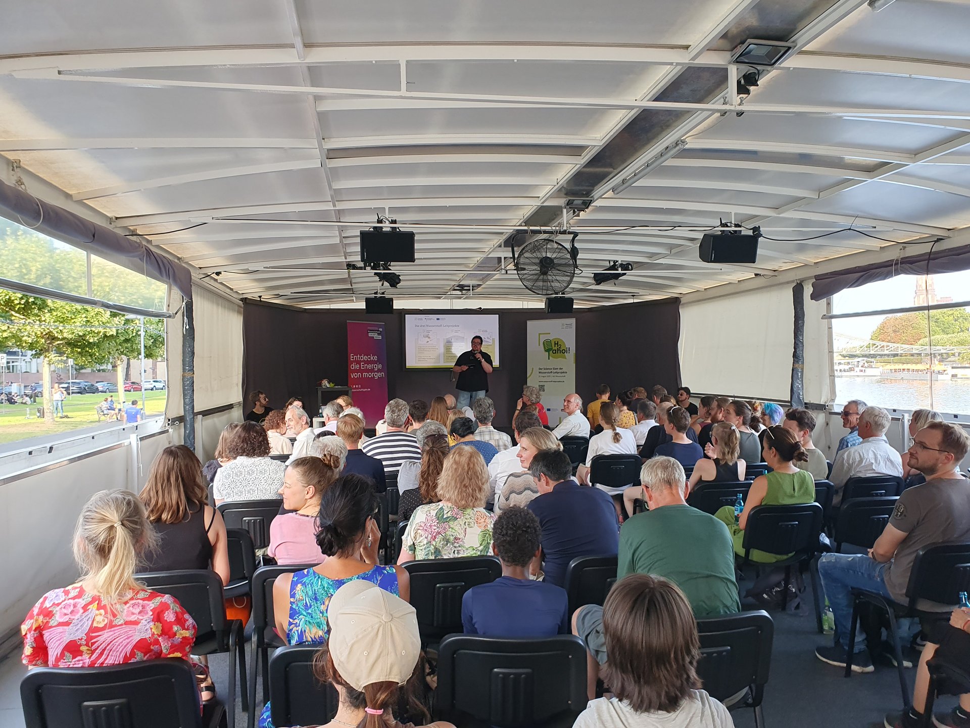 Ein Forscher stellt dem Publikum an Bord der MS Wissenschaft seine Forschungsergebnisse vor.