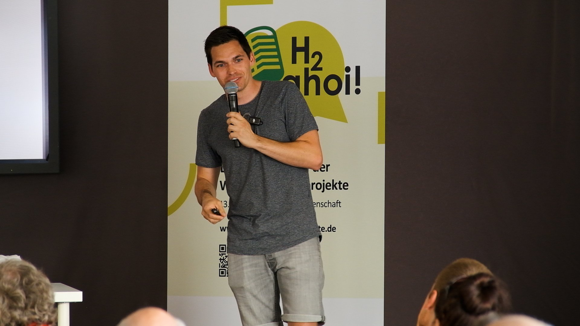 Philipp Weisenburger mit einem Mikrofon in der Hand.