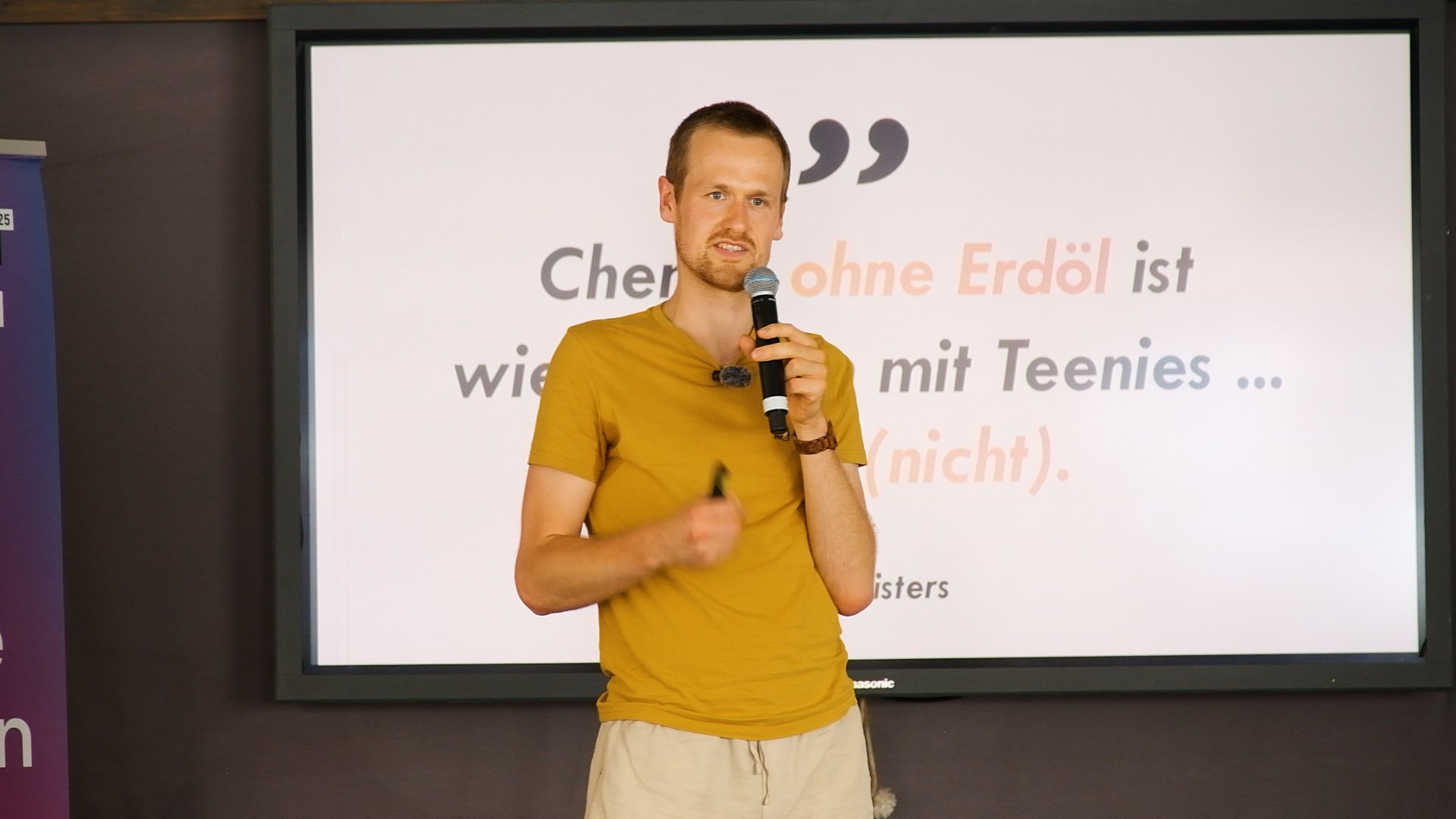 Arne Nisters vor einer Leinwand an Bord der MS Wissenschaft.