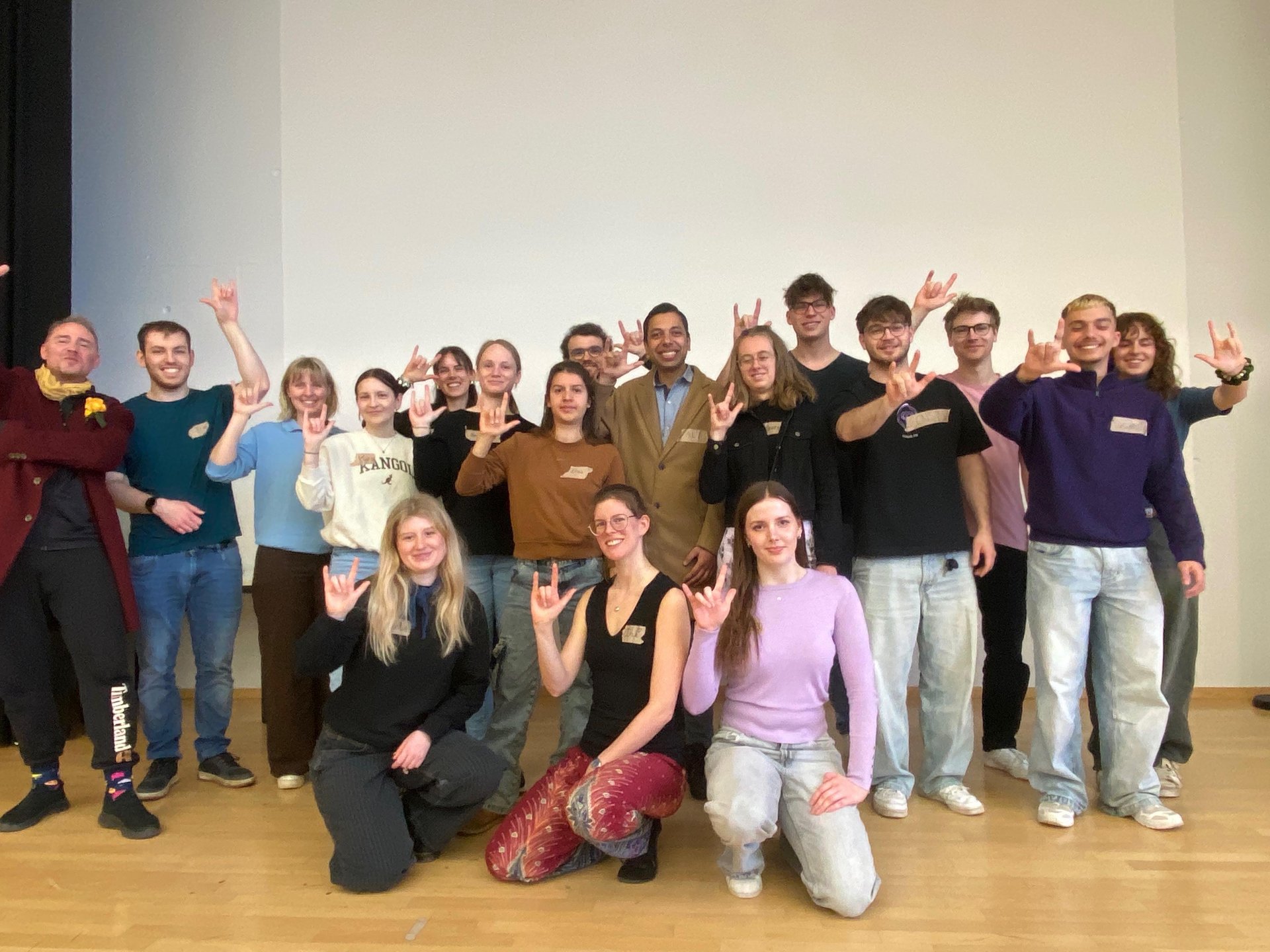 Die Studierenden von Energialogue posieren für ein Gruppenbild und zeigen das internationale Zeichen für Solidarität mit allen Gebärdensprachler:innen.