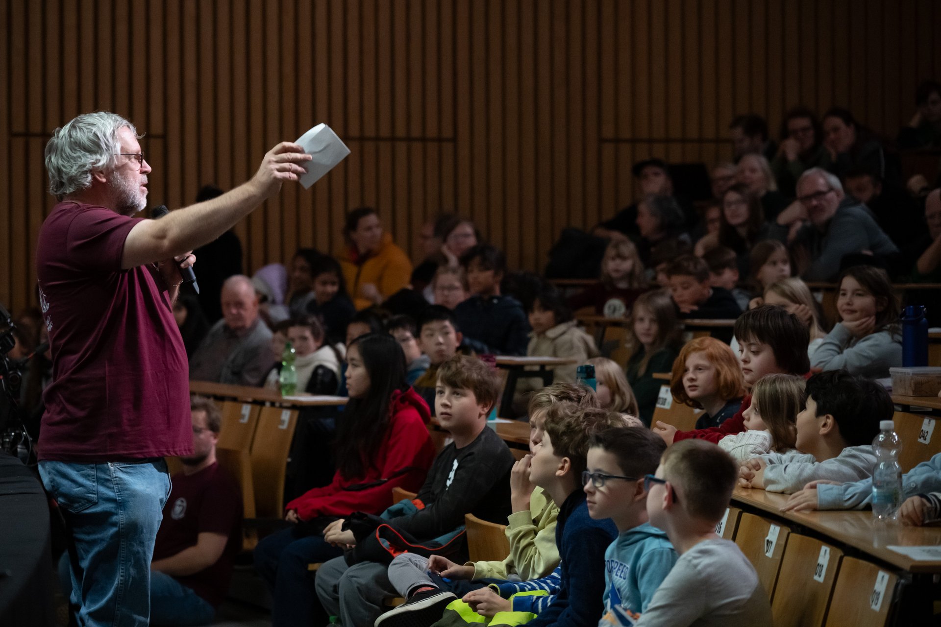 Moderator spricht vor Publikum.