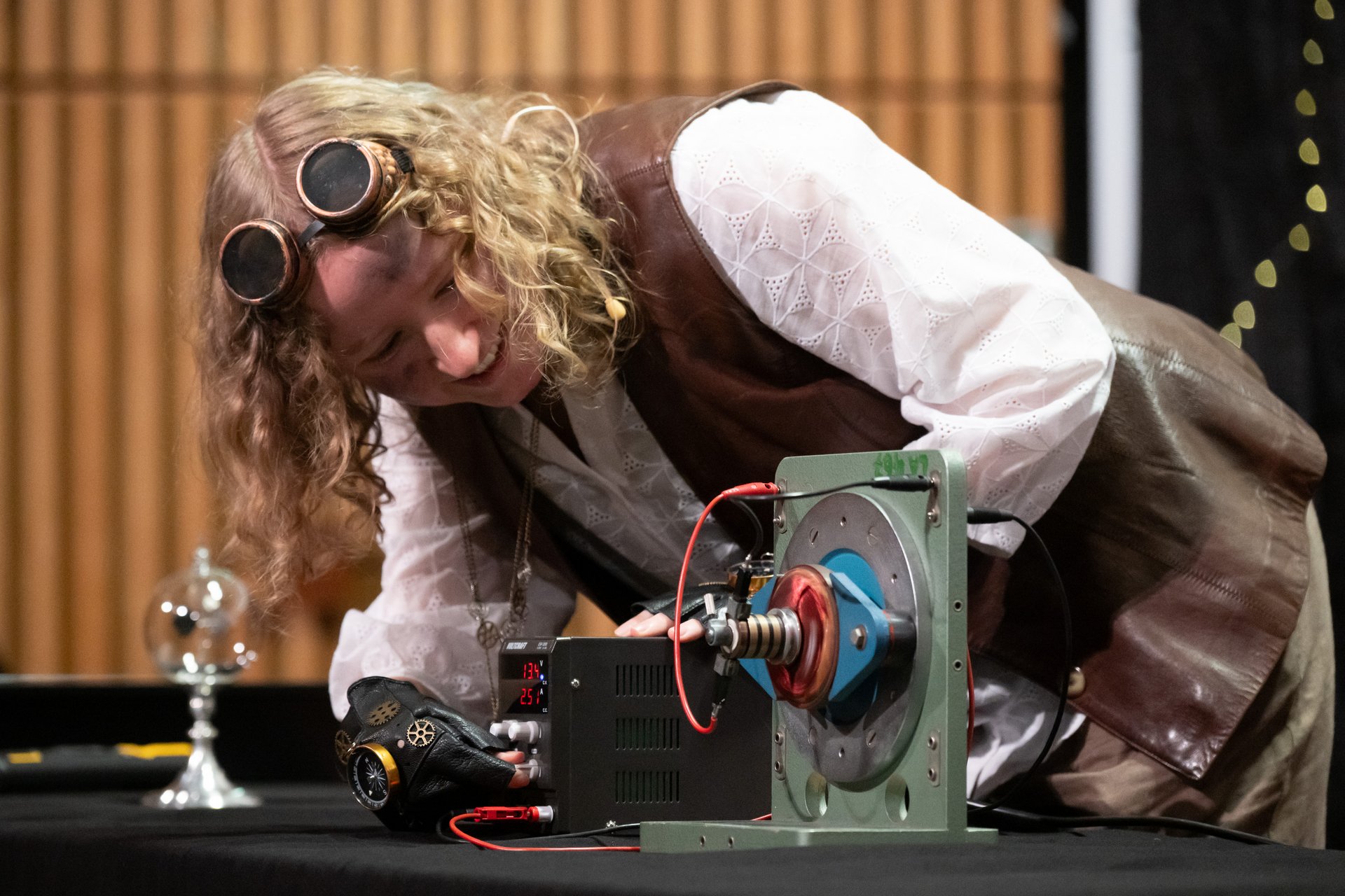 Verkleidete Schauspielerin dreht während eines Live-Experiments an einer Batterie. 