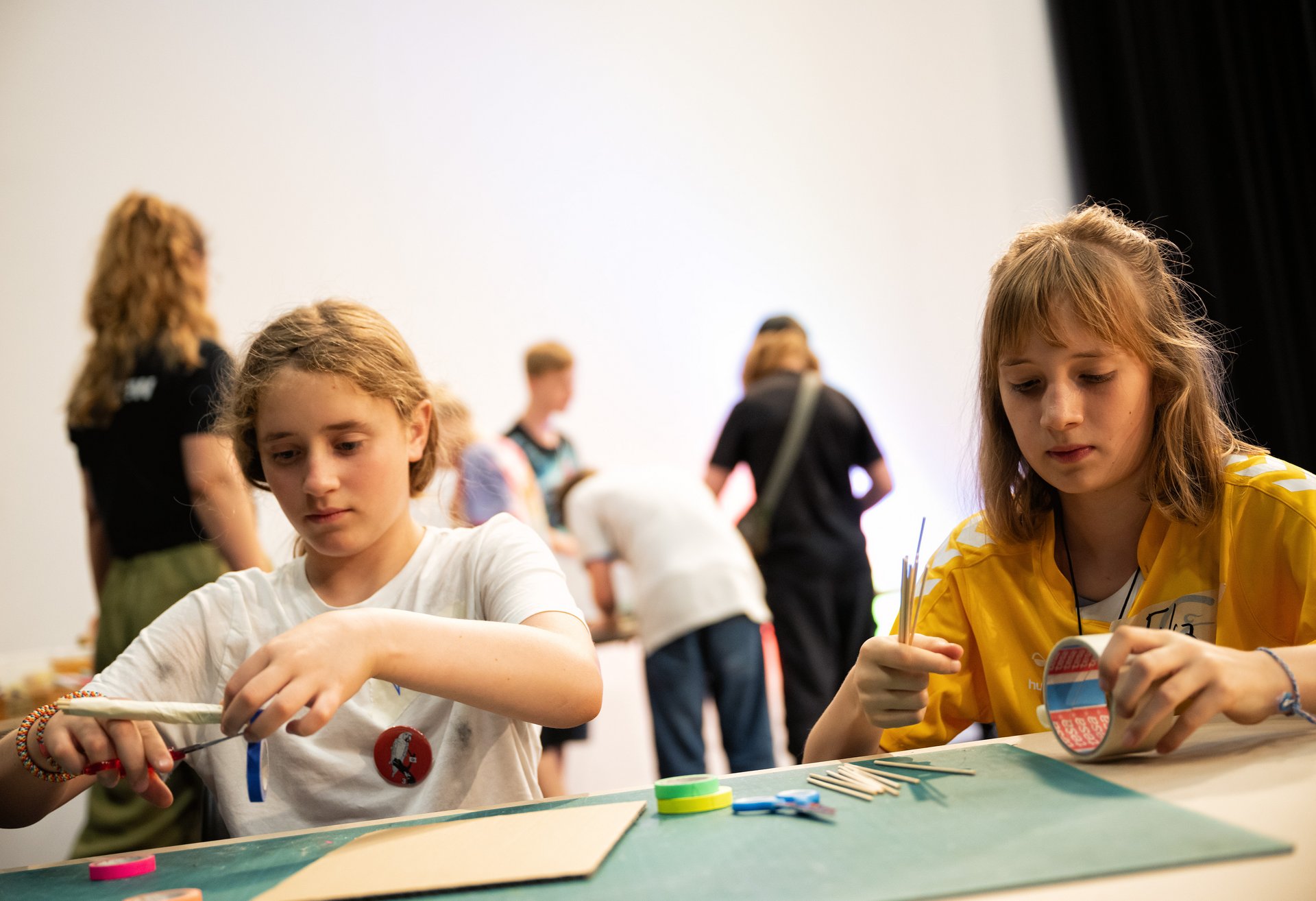 Zwei Schülerinnen basteln Windkraftmodelle.