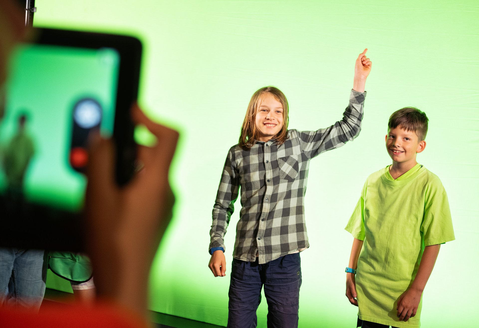 Zwei Schüler stehen vor einem Greenscreen.
