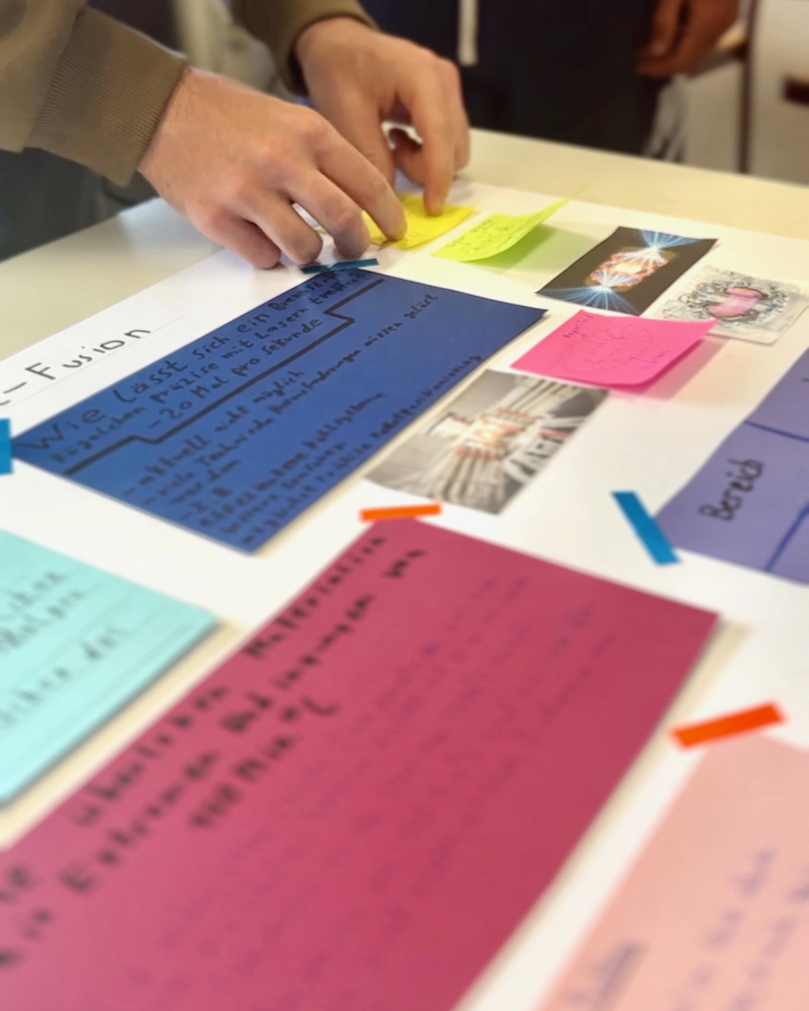 Auf einem Tisch liegen verschiedenfarbige Karten mit Text. Der Text ist nicht lesbar.
